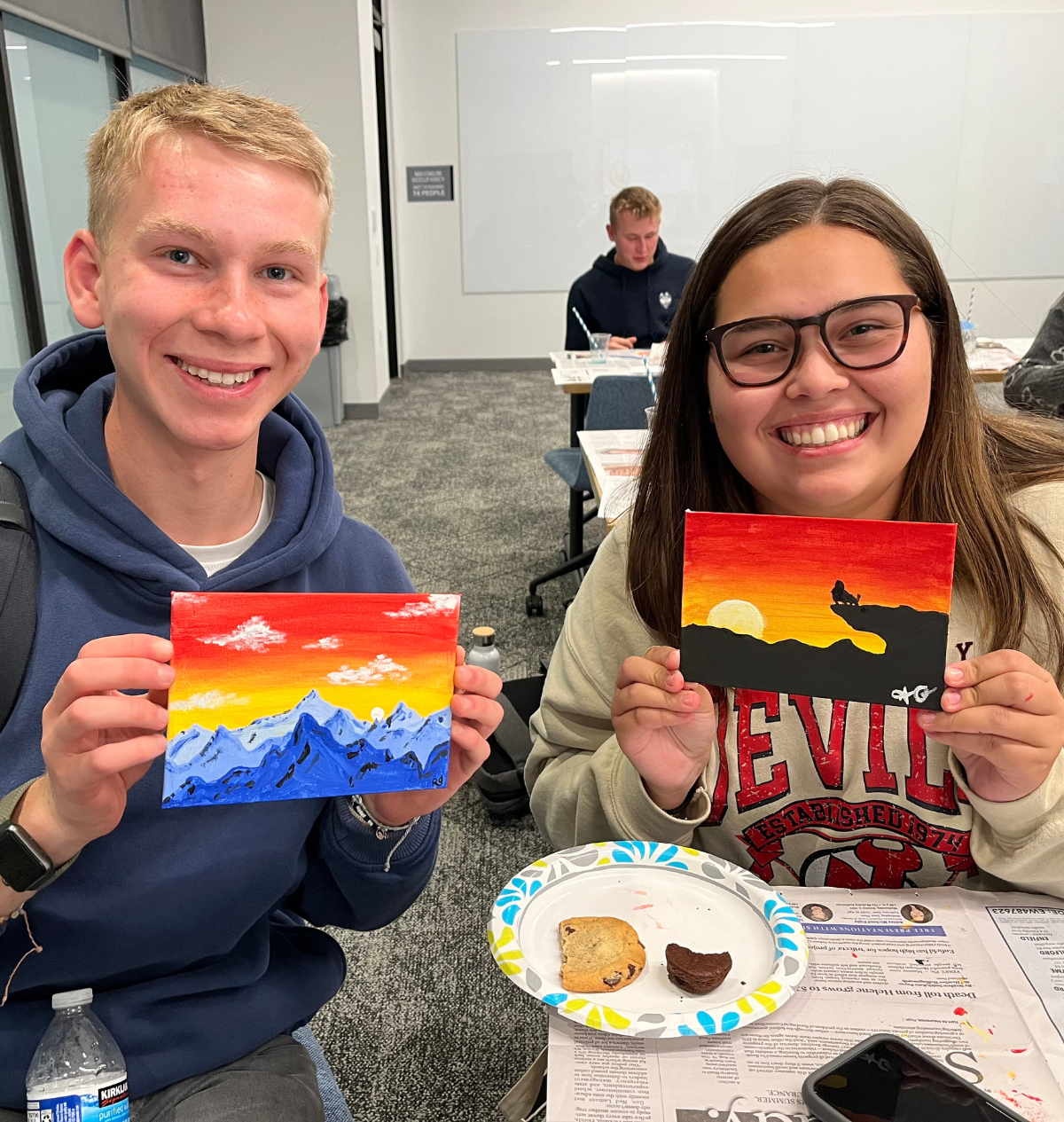 Two students holding up their painting