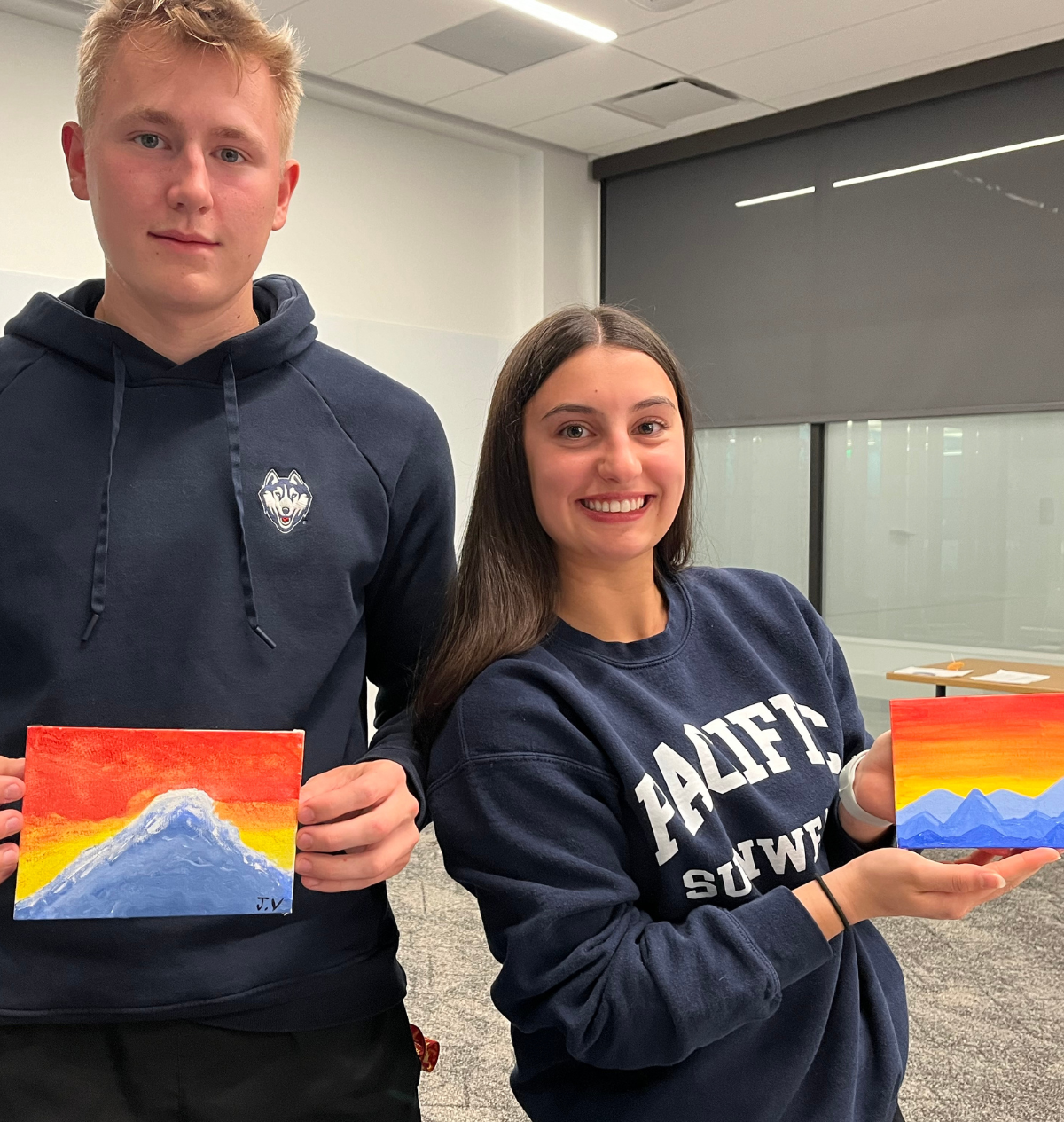 Two students holding up their painting