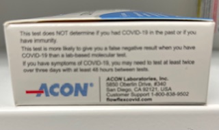 Close-up of the side of a COVID-19 rapid test kit box displaying informational text about test results and the ACOn Laboratories logo.